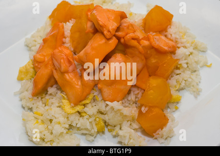 Poulet à l'ananas et des oeufs au plat à emporter chinois de riz sur une plaque blanche Banque D'Images