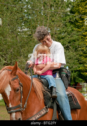 Ce vertical image montre une grand-mère de race blanche et serrant son sourire cute blonde 2 ans petite-fille. Banque D'Images