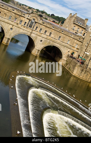 Grand angle vertical du grade 1 énumérés Pulteney Bridge traversant la rivière Avon dans le centre de Bath sur une journée ensoleillée. Banque D'Images