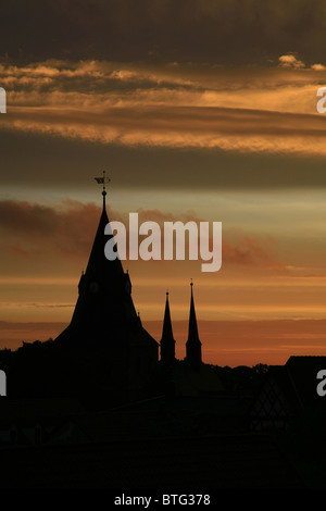 Clochers en silhouette contre une orange lever du soleil. Banque D'Images