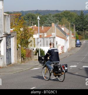 Équitation française factrice sa bicyclette peint jaune dans la ville rurale d'Aizenay Vendée de France Banque D'Images