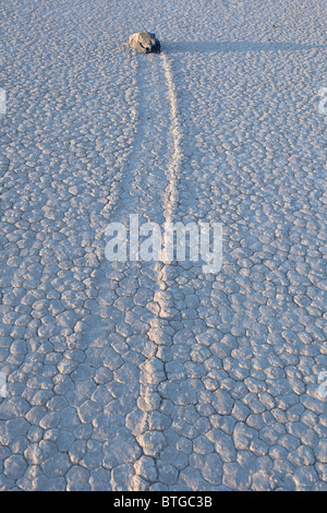 En le faisant glisser à gauche du sentier des roches qui se déplacent à travers l'Hippodrome mystérieusement Playa dans Death Valley National Park, California USA. Banque D'Images