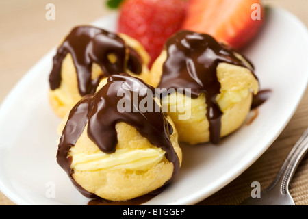 Profiterole couverts dans une sauce au chocolat Banque D'Images