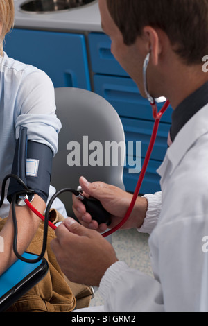 Médecin de prendre la pression artérielle du patient Banque D'Images