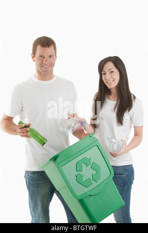 Jeter quelques bouteilles en verre et en plastique dans le bac de recyclage Banque D'Images