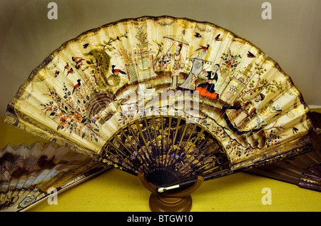 Magnifique ventilateur à main pliant antique du XVIIIe siècle avec des œuvres d'art chinoiserie complexes et des bâtonnets de laque, exposé sur un stand de présentation de galerie Banque D'Images
