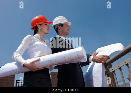 Plans professionnels holding at construction site Banque D'Images