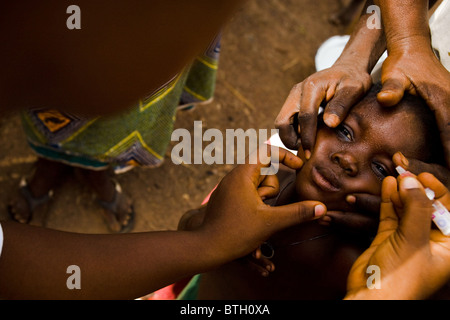 Un agent de santé vaccine un enfant contre la poliomyélite dans le village d'Gidan-Turu le nord du Ghana, le jeudi 26 mars 2009. Banque D'Images