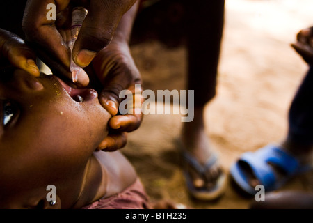 Une fille reçoit deux gouttes de vaccin contre la polio au cours d'un exercice national de l'immunisation contre la polio dans le nord du Ghana, Salaga Banque D'Images