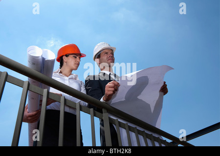 Plans professionnels holding at construction site Banque D'Images