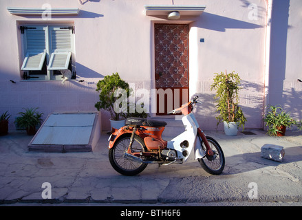 Petite maison avec une moto garée devant, ville d'Ermoupolis, île de Syros, Grèce Banque D'Images