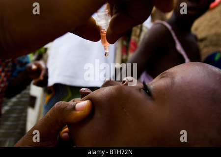 Un agent de santé vaccine un enfant contre la poliomyélite dans le village d'Gidan-Turu le nord du Ghana, le jeudi 26 mars 2009. Banque D'Images