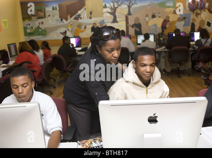 Spécialiste de l'informatique travaille avec des étudiants dans le laboratoire informatique de l'École de la communauté de Detroit un charter school à Detroit, MI Banque D'Images