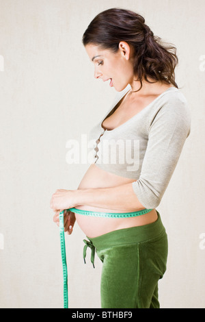 Pregnant woman measuring belly Banque D'Images