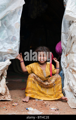 Les indiens pauvres basse caste baby girl à l'entrée de sa tente accueil fait à partir de sacs plastiques. L'Andhra Pradesh, Inde Banque D'Images