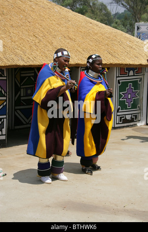 Les femmes Ndebele en costume traditionnel, Village Culturel Ndelebe, Botshabelo, Afrique du Sud. Chantant et jouant des instruments. Banque D'Images