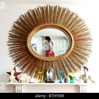 Reflet d'une femme dans un miroir orné Banque D'Images