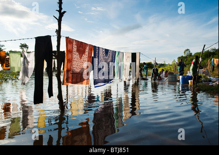 Laver les vêtements indiens par une rivière en crue dans la ville de Puttaparthi, Andhra Pradesh, Inde Banque D'Images