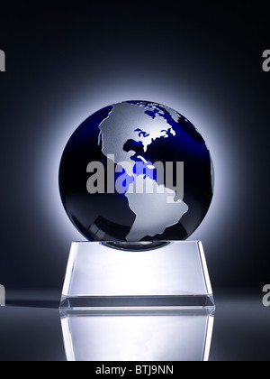 Un élégant trophée globe en verre repose sur un support en métal élégant, mettant en évidence les continents de l'Amérique du Nord et certaines parties de l'Amérique du Sud. Banque D'Images