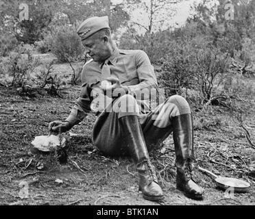 La Seconde Guerre mondiale, futur Président le général Dwight D. Eisenhower (1890-1969), s'arrêter pour midi ordinaire par la route pendant une tournée d'inspection en Tunisie. Le menu est une ration C, et chaud. Il a été gardé au chaud par d'être emballés en regard de l'admission de la voiture du général enroute, photographie, 1943. Banque D'Images