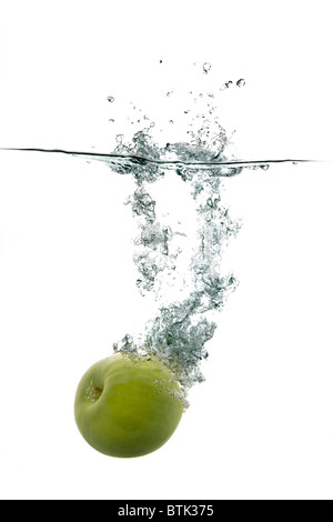Pomme verte fraîche tomber à l'eau Banque D'Images