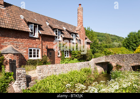 La rivière Aller peu profonde qui coule sous l'ancien pont à cheval à dos de meute à Allerford, Exmoor, Somerset, Royaume-Uni Banque D'Images