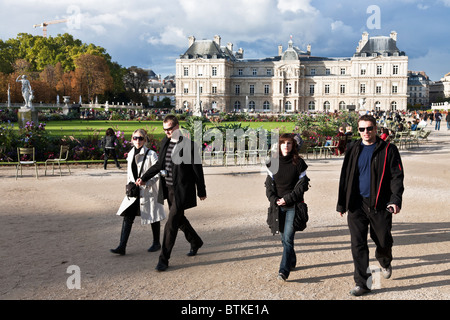 Deux jeunes couples parisiens marche à vive allure dans les jardins en face du Palais du Luxembourg sur un beau dimanche d'automne à Paris Banque D'Images