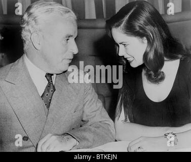 Charlie Chaplin (1889-1977) assis avec sa jeune épouse Oona au Hollywood night en 1944. Le couple se marie à l'année précédente, où 18 Oona et Charlie était était de 54. Banque D'Images