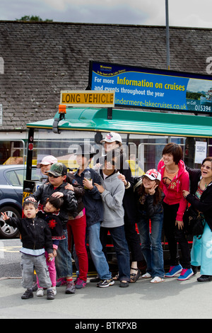 Les touristes japonais posent pour la photo de famille à côté de la route sur la journée à Bowness on Windermere sur le lac Windermere Banque D'Images