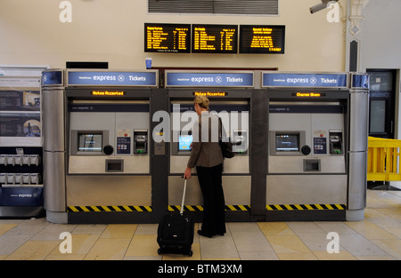 Femme de l'achat d'un billet de train pour voyager sur le service Heathrow Express pour Paddington Station west London UK Banque D'Images