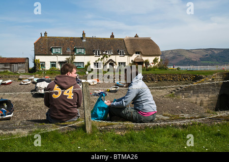 Dh PORLOCK WEIR SOMERSET Jeune couple pique-niques Porlock Weir Harbour et des chaumières Banque D'Images