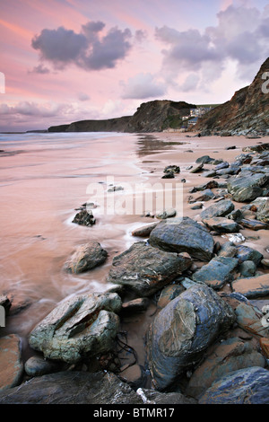 La plage à Watergate Bay sur la côte nord des Cornouailles capturé au coucher du soleil Banque D'Images