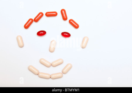 Médicaments et comprimés visage sur fond gris Banque D'Images