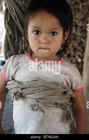 Un jeune 4 ans, fille de réfugiés Karen Paduang baidjan joue avec une corde swing dans un camp de réfugiés dans le nord de la Thaïlande. Banque D'Images