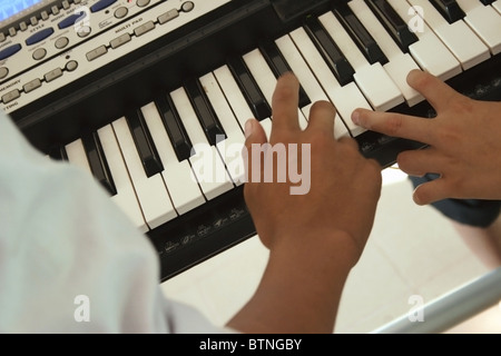 Les deux garçons sans vision sont la lecture d'un clavier synthétiseur au Centre national de réhabilitation à Vientiane au Laos. Banque D'Images