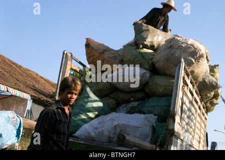 Les travailleurs sont le chargement d'un camion avec les sacs de matières recyclables à Kampong Cham, au Cambodge. Banque D'Images