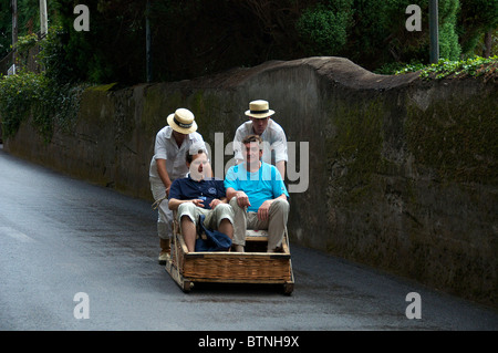 Deux hommes poussés en luge d'osier Monte Funchal Madeira Portugal Banque D'Images