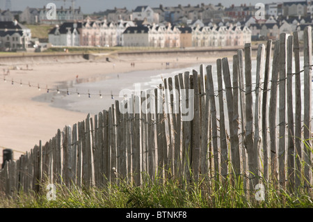 Vue brouillée lointain de Rush, Plage de port d'Irlande, clôture en bois au premier plan Banque D'Images