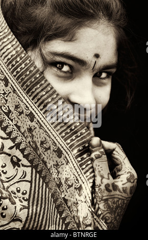 Indian girl wearing silk sari traditionnel au henné les mains. L'Inde. Face portrait. Sépia Banque D'Images