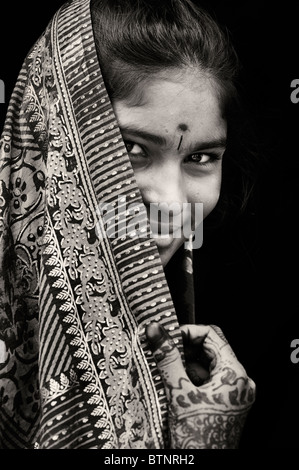 Indian girl wearing silk sari traditionnel au henné les mains. L'Inde. Face portrait. Sépia Banque D'Images