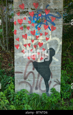 Le Graffiti montrant une jeune fille en noir coeur rouge laissant échapper / fly à partir de son tablier, mur à Munich, Allemagne Banque D'Images