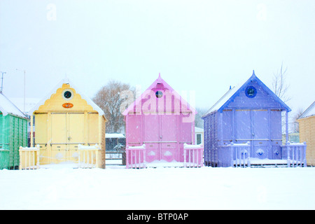 Cabines de plage close up dans une tempête de neige à West Mersea, Essex Banque D'Images