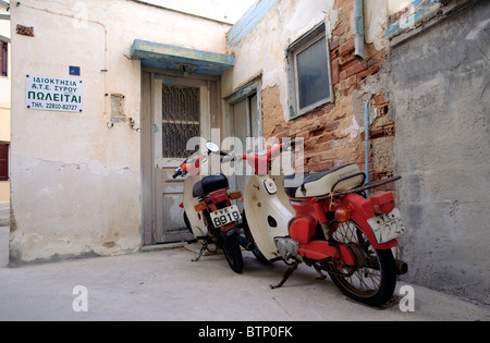 Deux scooters garé devant une maison à Ermoupolis, sur l'île de Syros Cyclades grecques. Banque D'Images