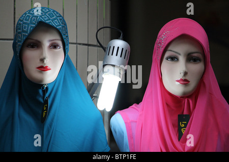 Deux mannequins portant des foulards de tête avec une lumière vive entre eux Banque D'Images