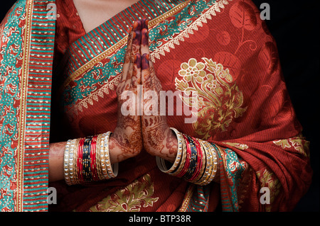 Indian girl wearing silk sari traditionnel au henné la prière les mains. L'Inde Banque D'Images