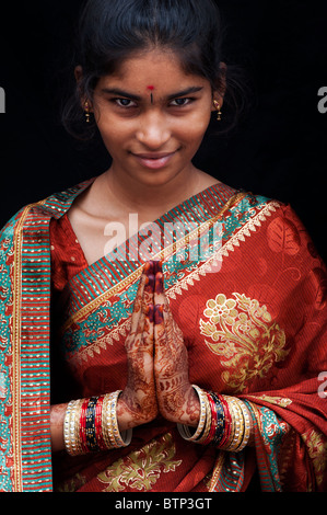 Indian girl wearing silk sari traditionnel au henné la prière les mains. L'Inde Banque D'Images