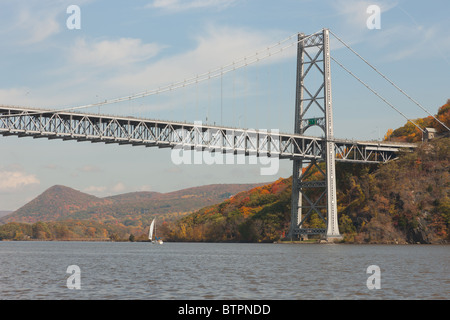 Un voilier sur le fleuve Hudson passe sous le pont de la montagne de l'ours à l'automne Banque D'Images