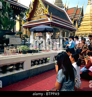 Les thaïs priant au culte en face du Temple du Bouddha Émeraude Grand Palace Thaïlande Asie du sud-est Banque D'Images