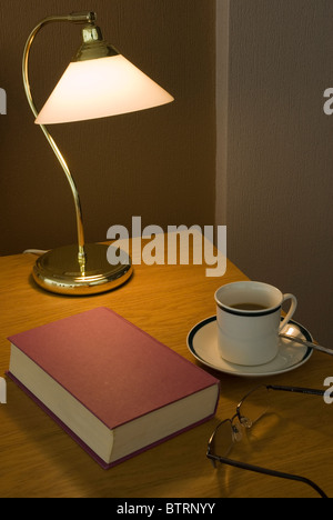 Livre et une tasse de café une lampe de table Banque D'Images