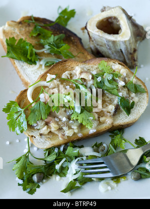 Rôti moelle d'os servi avec du pain grillé et du persil oignon et câpres - nez à queue mangeant - un exemple de la nourriture étrange ou bizarre mangée par les gens Banque D'Images